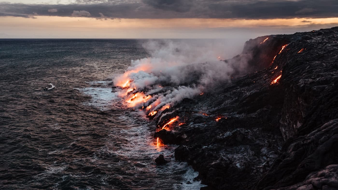 Glowing lava from a Big Island volcano meeting the ocean at dusk