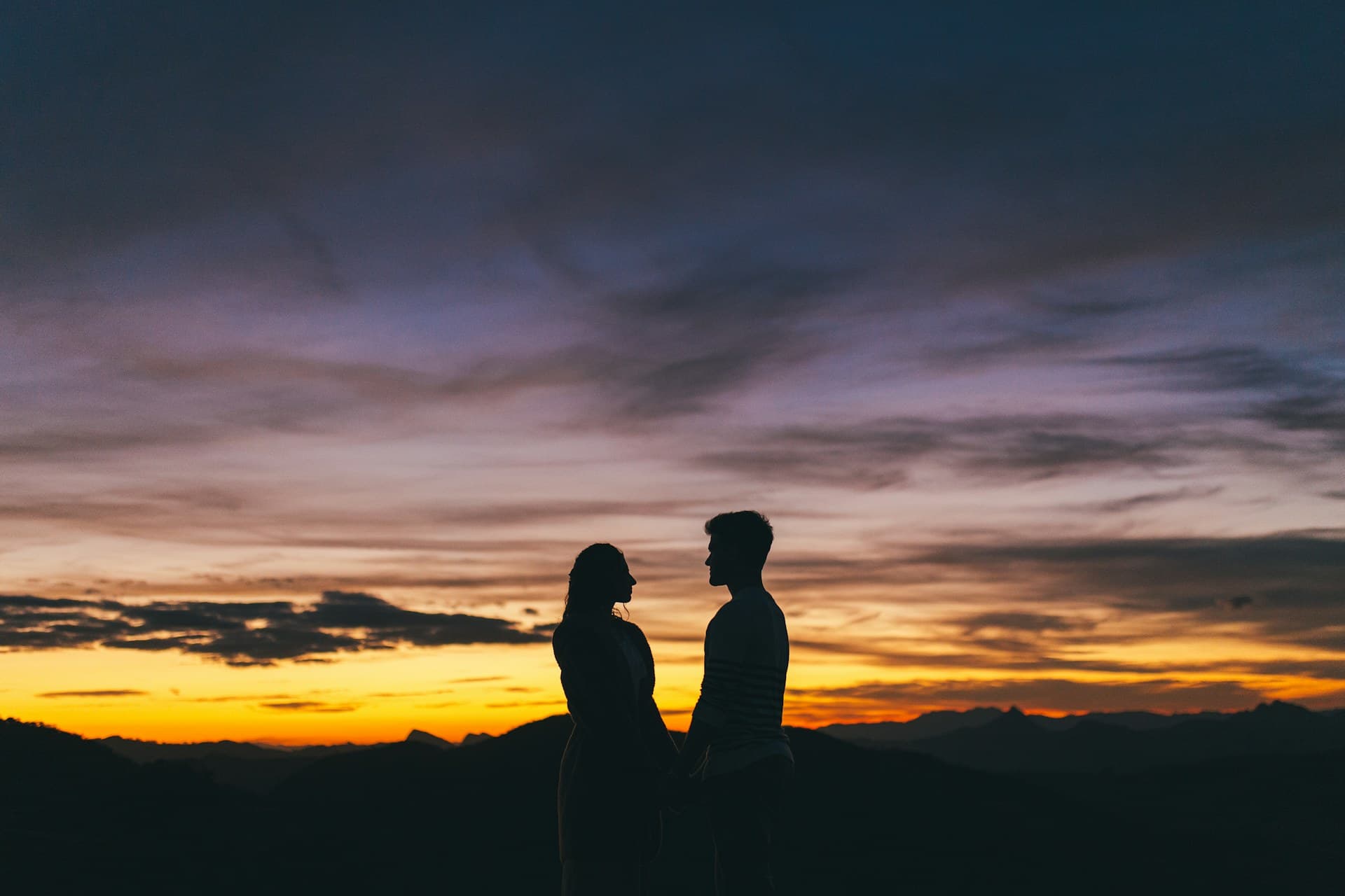A couple looking out over the Teton Range at golden hour