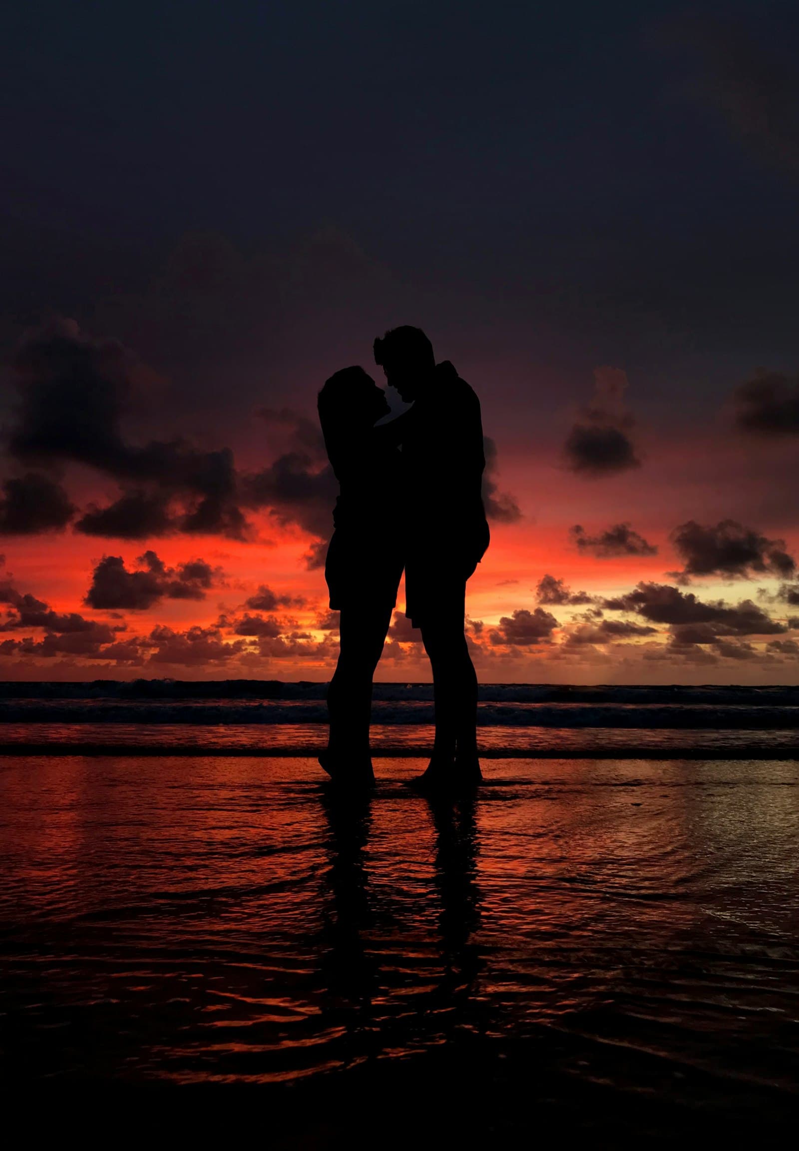A couple on a Kauai beach at golden-hour sunset