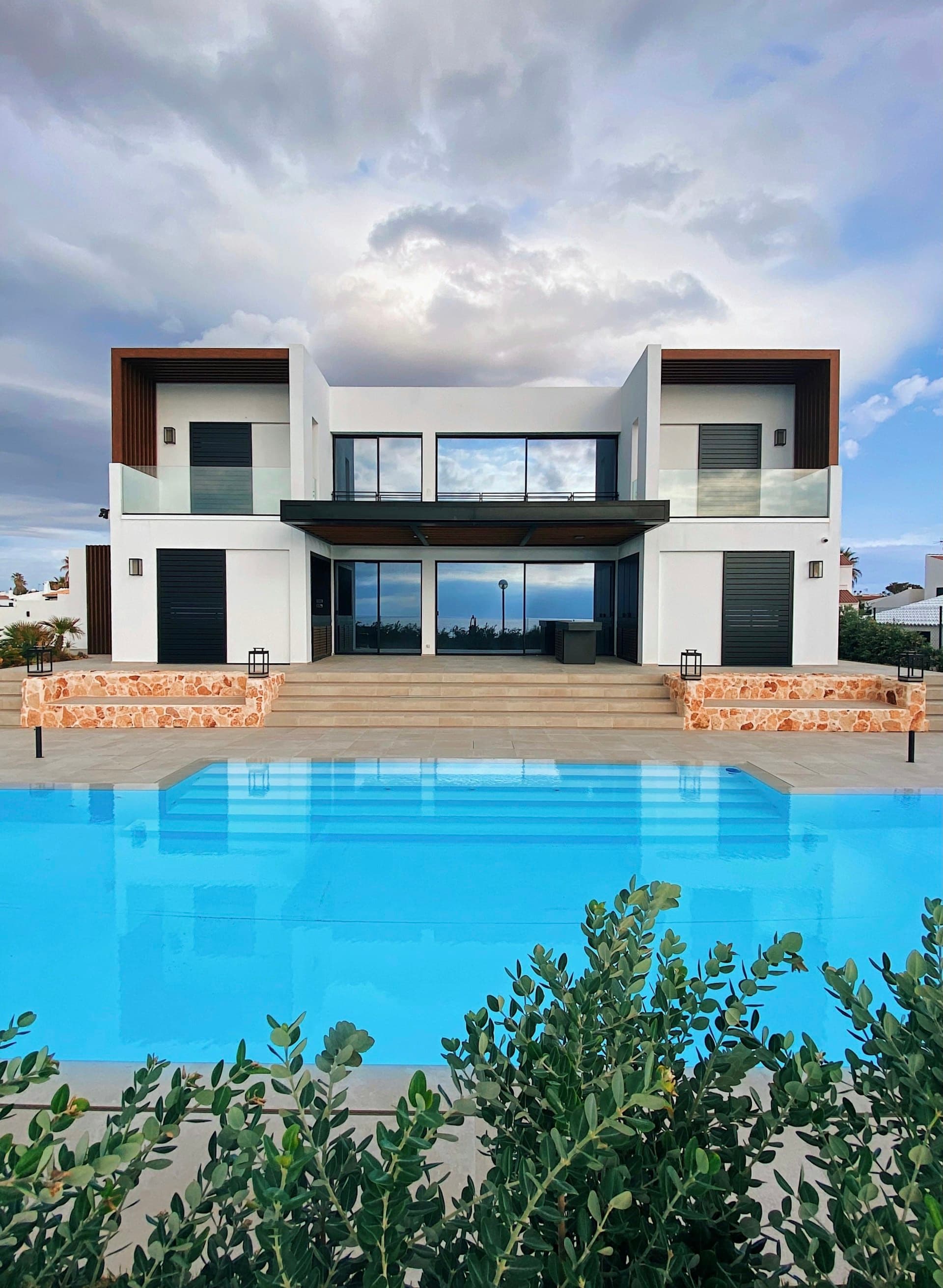 A luxury coastal lodge pool with forest beyond
