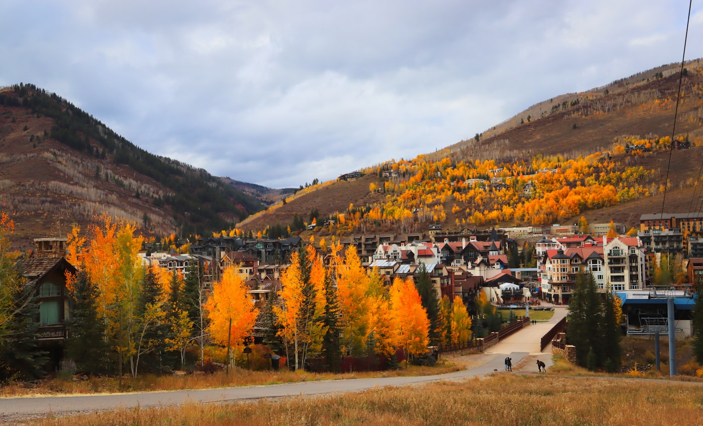 A Colorado ski village framed by snow-dusted mountains at dusk in Vail